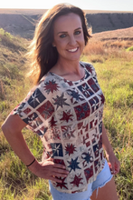 Load image into Gallery viewer, Woman wearing a colorful patterned shirt in a grassy field