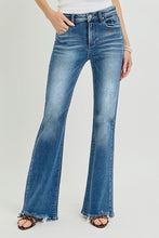 Load image into Gallery viewer, Blue flared jeans worn by a person on a light gray background