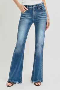 Blue flared jeans worn by a person on a light gray background
