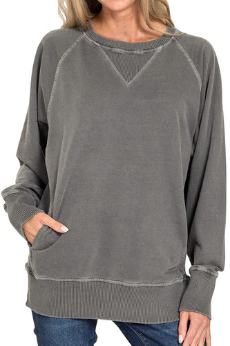 Woman wearing a gray sweatshirt with a plain background