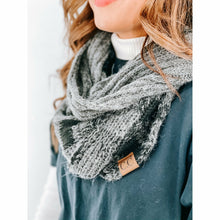 Load image into Gallery viewer, Gray knitted scarf with a brand tag worn by a person on a white background