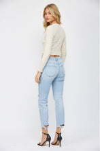 Load image into Gallery viewer, Woman wearing a cream sweater and light blue jeans on a white background
