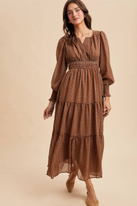 Woman wearing a brown patterned dress on a beige background