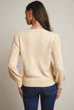 Load image into Gallery viewer, Woman wearing a beige sweater with cable knit details on a plain background