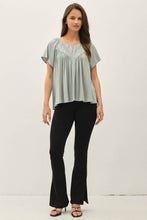 Load image into Gallery viewer, Woman wearing a light green blouse and black pants on a white background