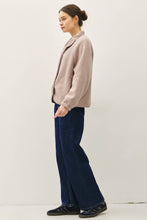 Load image into Gallery viewer, Woman wearing a light pink jacket and dark blue pants on a white background