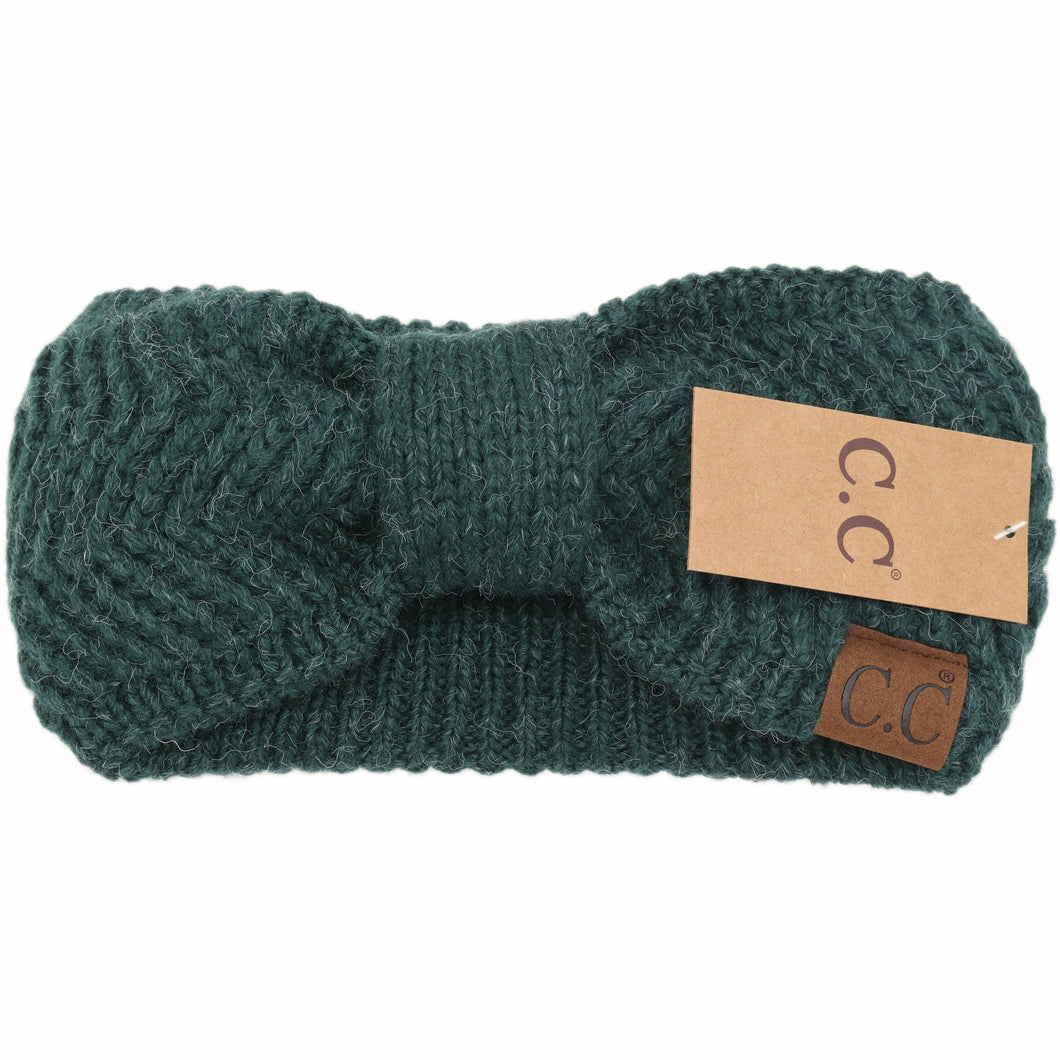 Green knitted headband with a brand tag on a white background