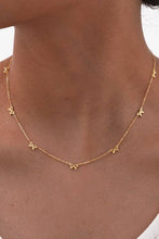 Load image into Gallery viewer, Gold necklace with star-shaped pendants on a person's neck