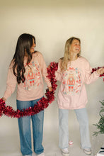 Load image into Gallery viewer, Two people wearing matching pink sweatshirts with a Christmas design, holding red tinsel against a plain background.