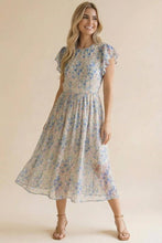 Load image into Gallery viewer, Woman wearing a floral dress against a beige background