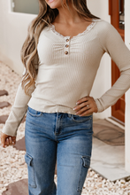 Load image into Gallery viewer, Woman wearing a beige ribbed long-sleeve top and blue jeans outdoors.