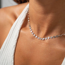 Load image into Gallery viewer, Close-up of a silver necklace on a person wearing a white top.
