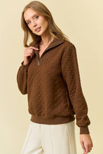 Load image into Gallery viewer, Woman wearing a brown quilted jacket on a beige background