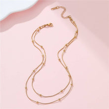 Load image into Gallery viewer, Gold necklace on a pink background