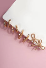 Load image into Gallery viewer, Set of rose gold hoop earrings on a white stand against a pink background