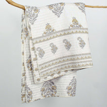 Load image into Gallery viewer, White quilt with floral patterns draped over a wooden rod on a light gray background