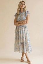 Load image into Gallery viewer, Woman wearing a floral dress against a beige background