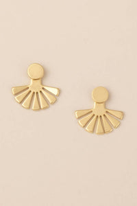 Gold earrings on a beige background
