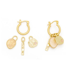 Set of gold hoop earrings with various charms on a white background