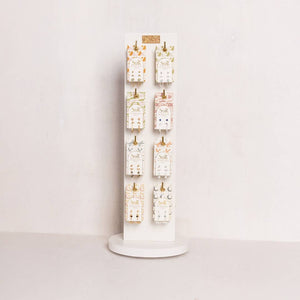 Earring display stand with multiple pairs of earrings on a white background