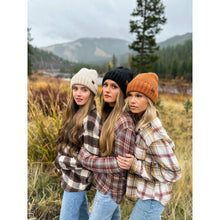 Load image into Gallery viewer, Three women wearing plaid shirts and beanies in a field with mountains in the background