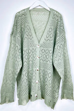 Load image into Gallery viewer, Green knitted cardigan on a white hanger against a white background