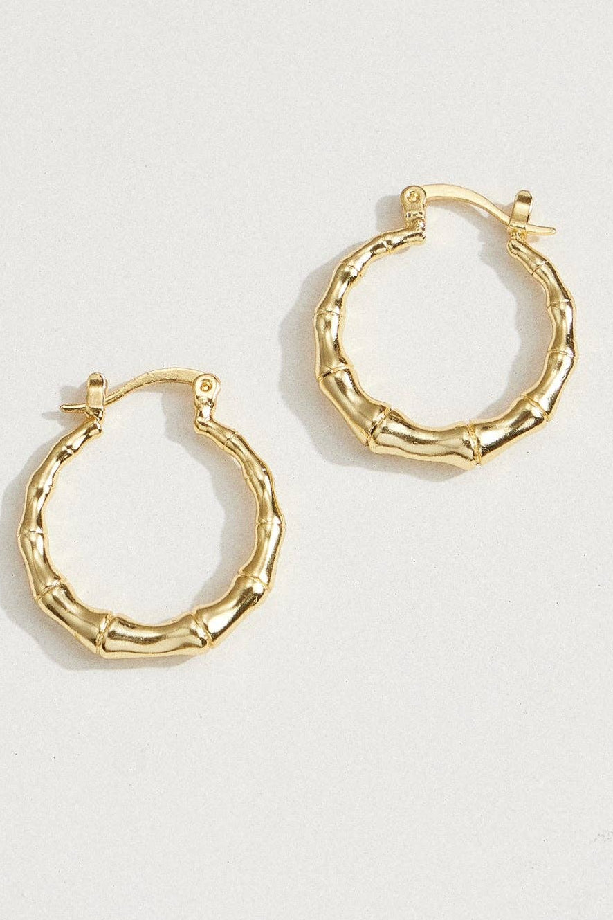 Gold hoop earrings on a light background