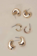Load image into Gallery viewer, Set of gold hoop earrings on a beige background