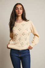 Load image into Gallery viewer, Woman wearing a beige sweater with floral patterns against a plain background