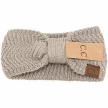 Load image into Gallery viewer, Knitted headband with a brand tag on a white background