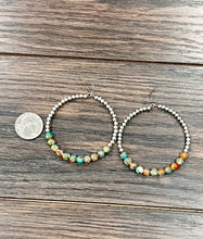 Load image into Gallery viewer, Hoop earrings with bead detailing on a wooden surface, next to a quarter for scale.