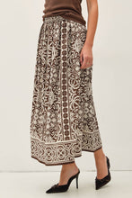 Load image into Gallery viewer, Person wearing a patterned skirt with a plain background