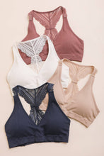 Load image into Gallery viewer, Four bras in different colors on a beige background