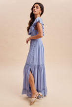 Load image into Gallery viewer, Woman wearing a light blue dress with ruffled sleeves on a beige background