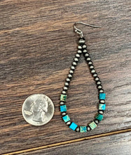 Load image into Gallery viewer, Beaded earring with turquoise accents next to a quarter on a wooden surface