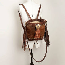 Load image into Gallery viewer, Brown leather backpack with fringe and concho on a mannequin against a plain background