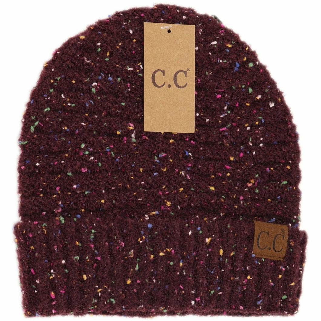 Multicolored speckled knit beanie with 'C.C' label on a white background