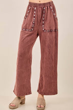 Load image into Gallery viewer, Brown corduroy pants with decorative buttons on a beige background