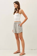 Load image into Gallery viewer, Woman wearing a white top and plaid shorts on a plain background