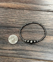 Load image into Gallery viewer, Beaded bracelet on a wooden surface with a coin for scale