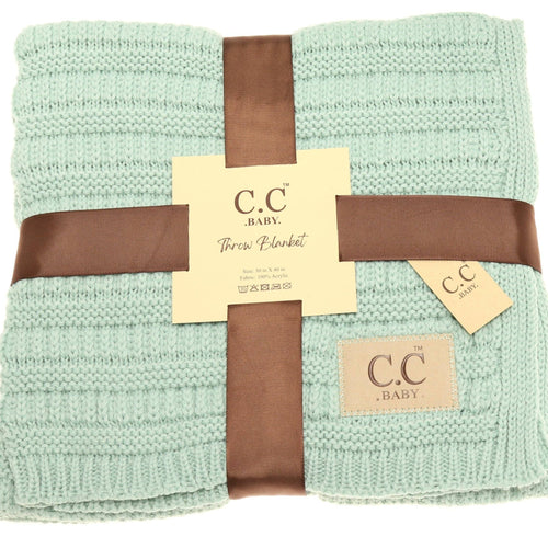 Folded green blanket with brown ribbon and C.C Baby label on a white background