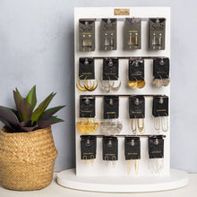 Load image into Gallery viewer, Display of Scout earrings on a white stand with a plant beside it.