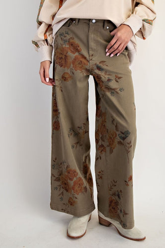 Woman wearing olive trouser with flower pant against white background wall