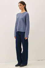 Load image into Gallery viewer, Woman wearing a blue knitted sweater and dark jeans on a white background