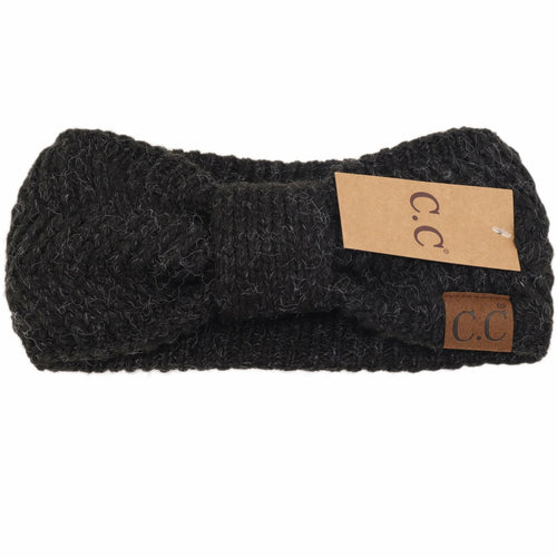 Black knitted headband with a brand tag on a white background