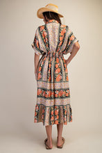 Load image into Gallery viewer, Woman wearing a patterned dress with a hat on a beige background