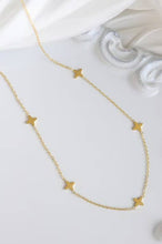 Load image into Gallery viewer, Gold necklace with star pendants on a white surface