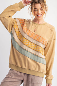 Woman wearing a beige sweater with colorful stripe pattern on a white background