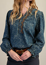 Load image into Gallery viewer, Woman in hat wearing floral denim blouse with beige background