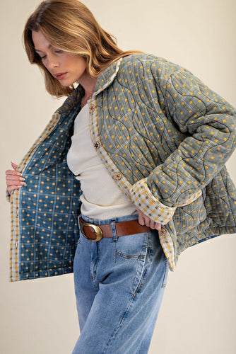 WOMAN WEARING QUILTED JACKET IN SAGE GREEN COLOR WITH YELLOW ACCENTS